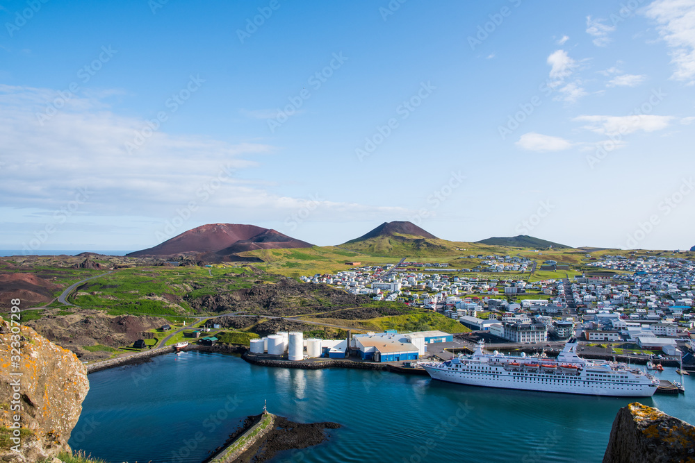 View over town of Heimaey and volcano Helgafell and Eldfell in Iceland