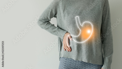 Photos Woman in casual grey clothes suffering from indigestion pain, highlighted vector