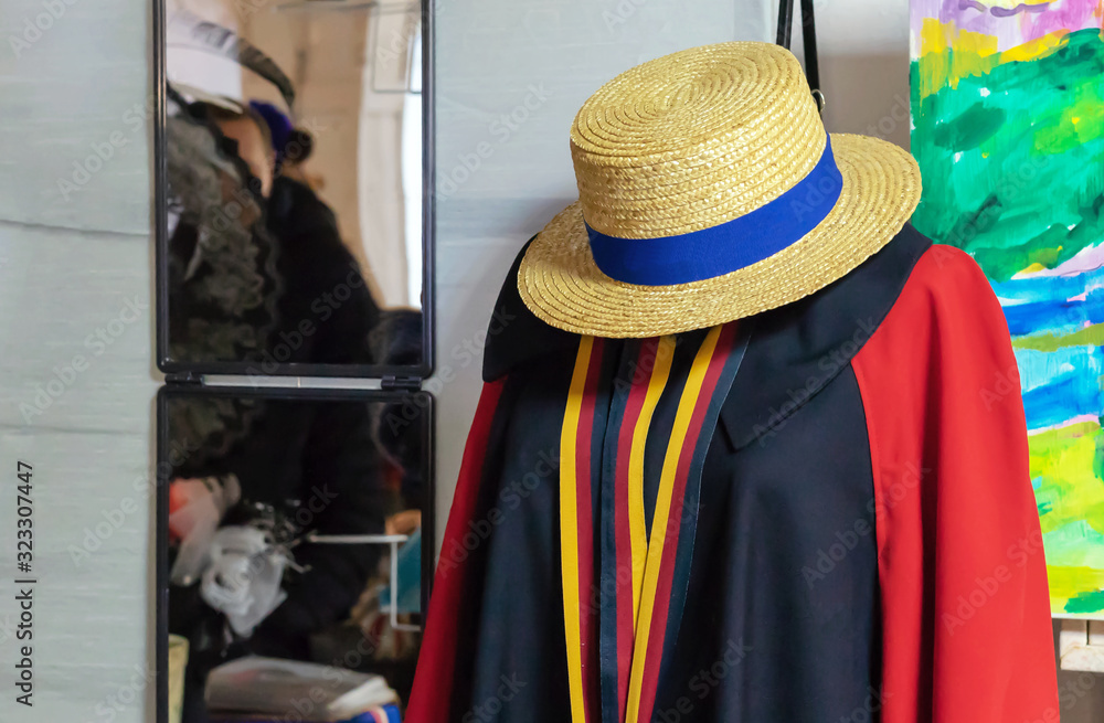 Female mannequin with a red cardigan and a straw hat.