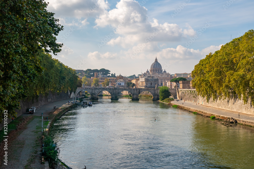St. Peter's cathedral over bridge and Tiber river water at autumn day Rome