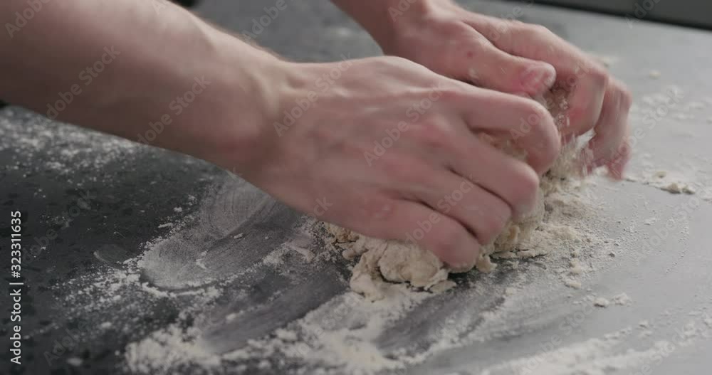 Slow motion man working with dough on concrete countertop Slow motion man working with dough on concrete countertop