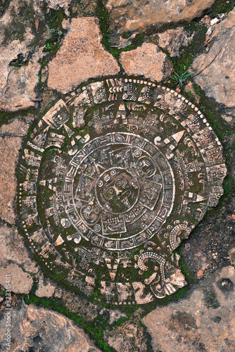 Mayan stone ruin on the ground with green