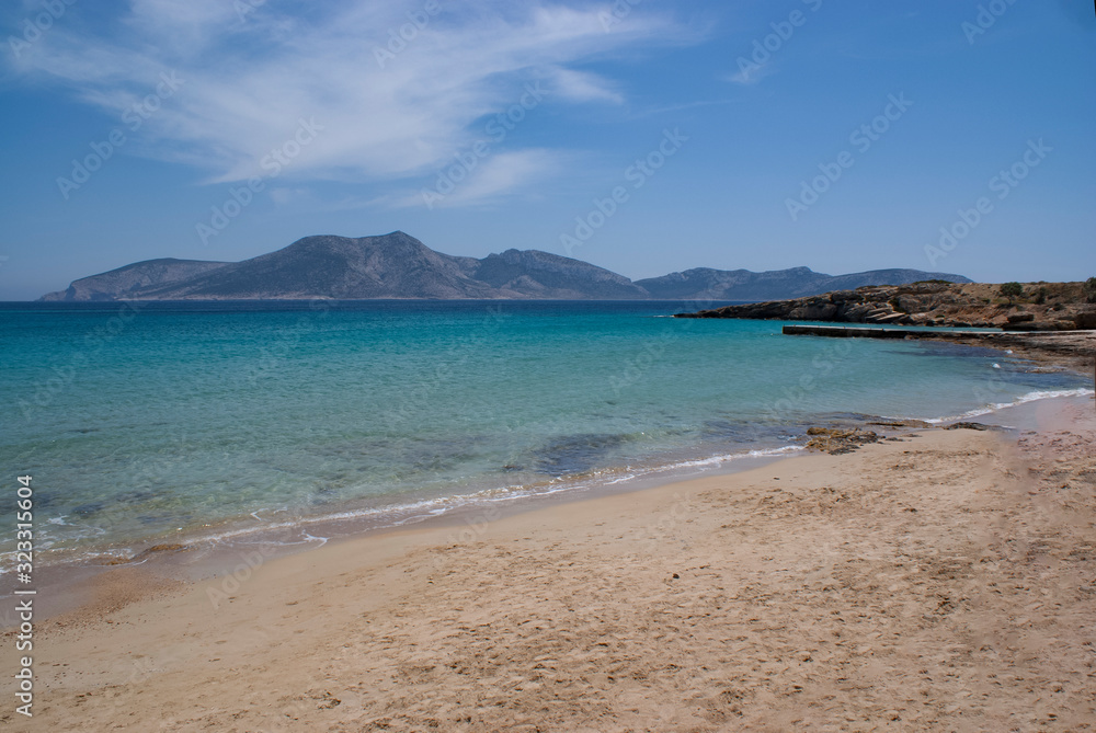 A tranquil, quiet beach on the beautiful Greek island of Koufonissi set in the Cyclades. A view from the pale sand of the shore to the island of Keros on the horizon. 