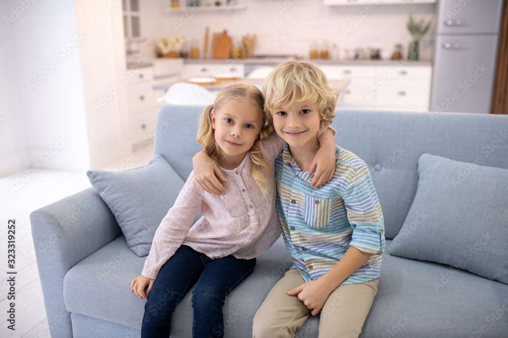 Two blod kids sitting next to each other and hugging Two blod kids sitting next to each other and hugging