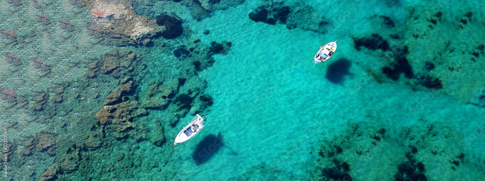 Fototapeta premium Aerial drone ultra wide photo of traditional fishing boat docked in seaside village of Polonia, Milos island, Cyclades, Greece