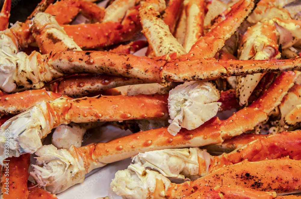 Delicious cooked king crab legs piled up on butchers paper - ready to eat - selective focus Delicious cooked king crab legs piled up on butchers paper - ready to eat - selective focus