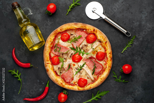  meat pizza with cheese, chicken, ham, champion mushrooms, tomatoes on a stone background