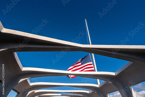 Oahu, Hawaii, USA. - January 10, 2012: Pearl Harbor. US Flag half pole over USS Arizona against blue sky. Seen through open ceiling of memorial.