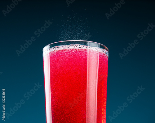 Canvastavla Glass filled to the brim with strawberry lemonade, on a blue background