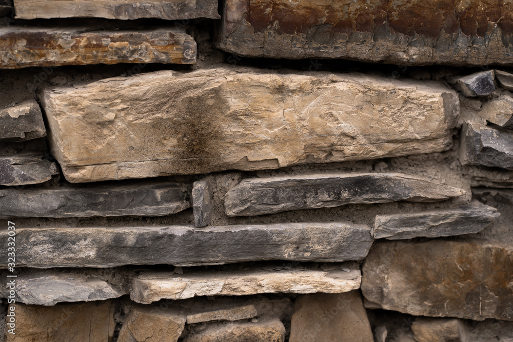 pattern gray color of modern style design decorative uneven cracked real stone wall surface with cement.Stone wall for background. Stone wall texture. Part of a stone wall, for background or texture