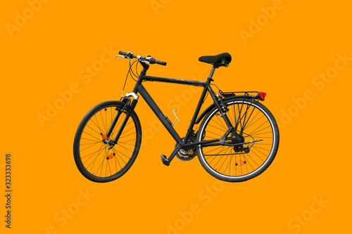 Old black bike isolated on orange background