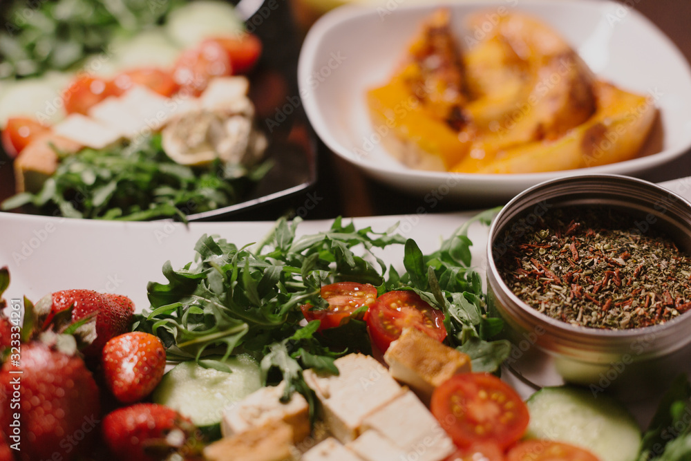 Vegetarian lunch bowl detox: sliced vegetables: cucumbers and tomatoes with herbs, spices and red strawberries and tofu, banana, pumpkin Vegetarian lunch bowl detox: sliced vegetables: cucumbers and tomatoes with herbs, spices and red strawberries and tofu, banana, pumpkin