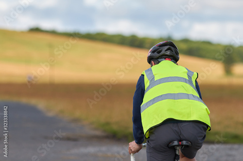 Cyclist riding bike wearing safety vest for high visability 