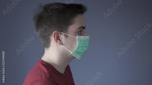 Virus infection protection measures. Young guy puts a medical mask on face. Protection from pathogenic bacteria. Corona virus and influenza viruses medical defend and epidemic precautions