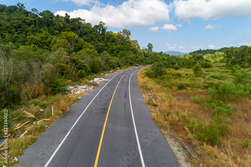 Asphalt road curve with yellow line on road image by drone camera high angle view.
