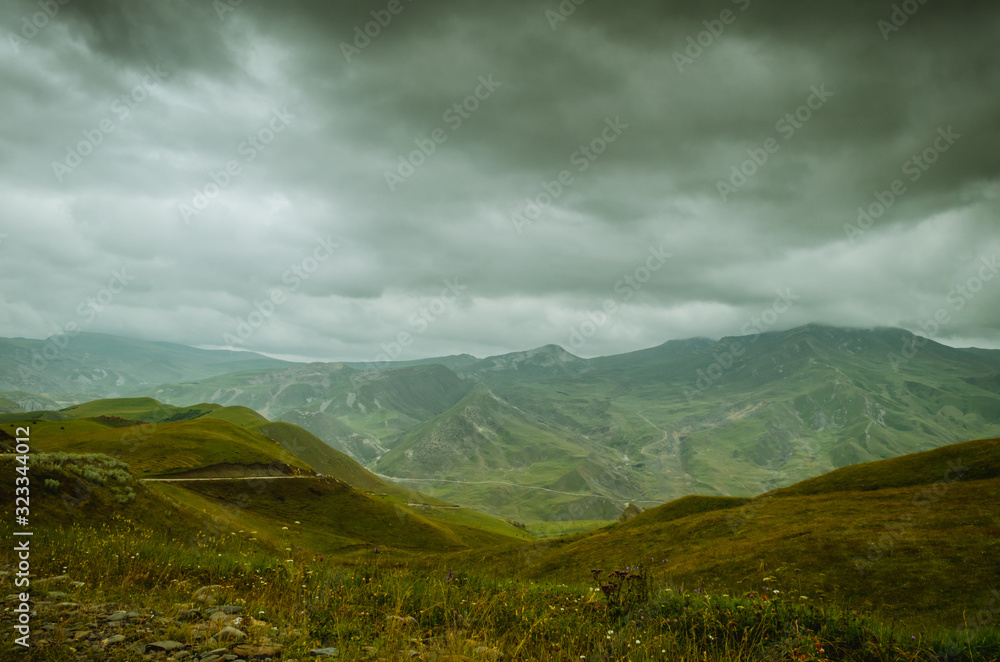 Fototapeta premium Cycling mountain road. Misty mountain road in high mountains.. Cloudy sky with mountain road