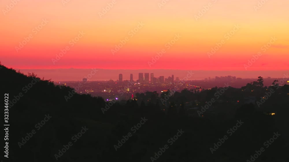Aerial, rising, drone shot,over hills in Griffith park, towards the Los Angeles city skyline, colorful dusk, in California, United states Aerial, rising, drone shot,over hills in Griffith park, towards the Los Angeles city skyline, colorful dusk, in California, United states