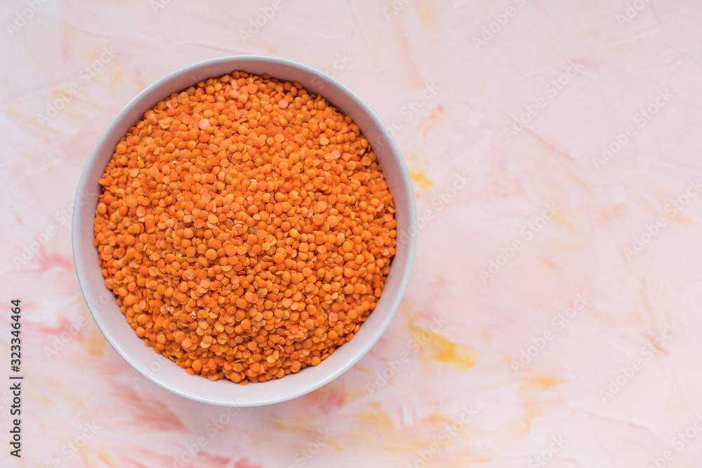 Raw red lentils in ceramic bowl on pink background, concept of healthy eating vegan food. Close up, top view, selective focus, copy space Raw red lentils in ceramic bowl on pink background, concept of healthy eating vegan food. Close up, top view, selective focus, copy space