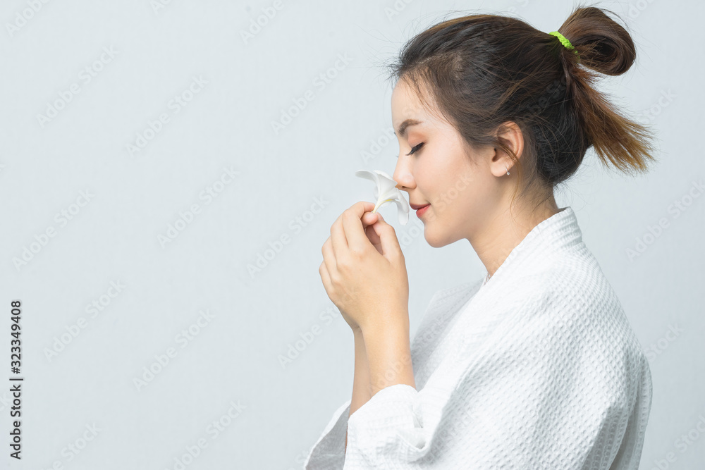 Beautiful young asian woman beside in spa uniform with flower. Beauty face care concept. Beautiful young asian woman beside in spa uniform with flower. Beauty face care concept.