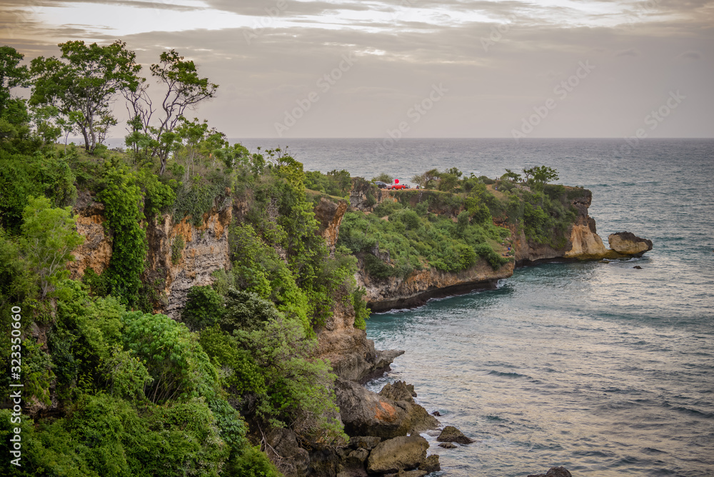 Fototapeta premium A view of Idian Ocean from Bali, Indonesia. Beautiful blue ocean water and a hanging cliff by the sea