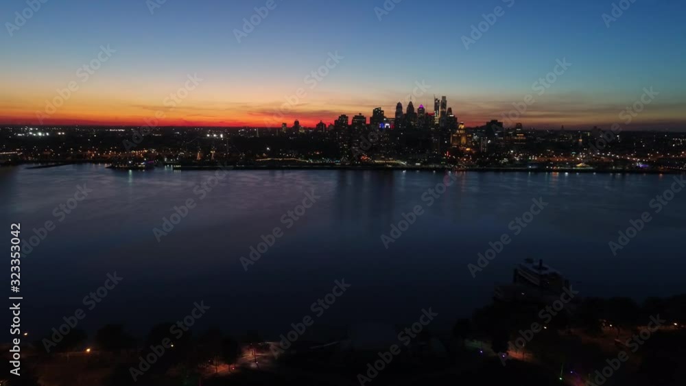Fascinating 4k aerial drone view on bright orange evening sunset sky over dark light city Philadelphia by ocean seascape Fascinating 4k aerial drone view on bright orange evening sunset sky over dark light city Philadelphia by ocean seascape