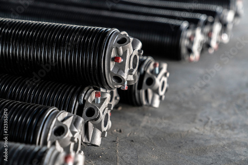 Commercial garage door springs stacked on a concrete floor