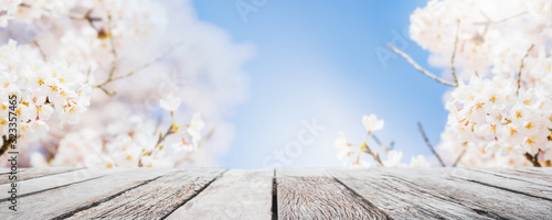 Empty wood table top and blurred sakura flower tree in garden background with vintage filter - can used for display or montage your products.