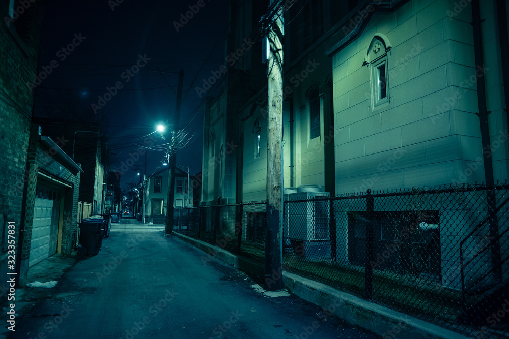 Dark and eerie urban city alley at night in the winter