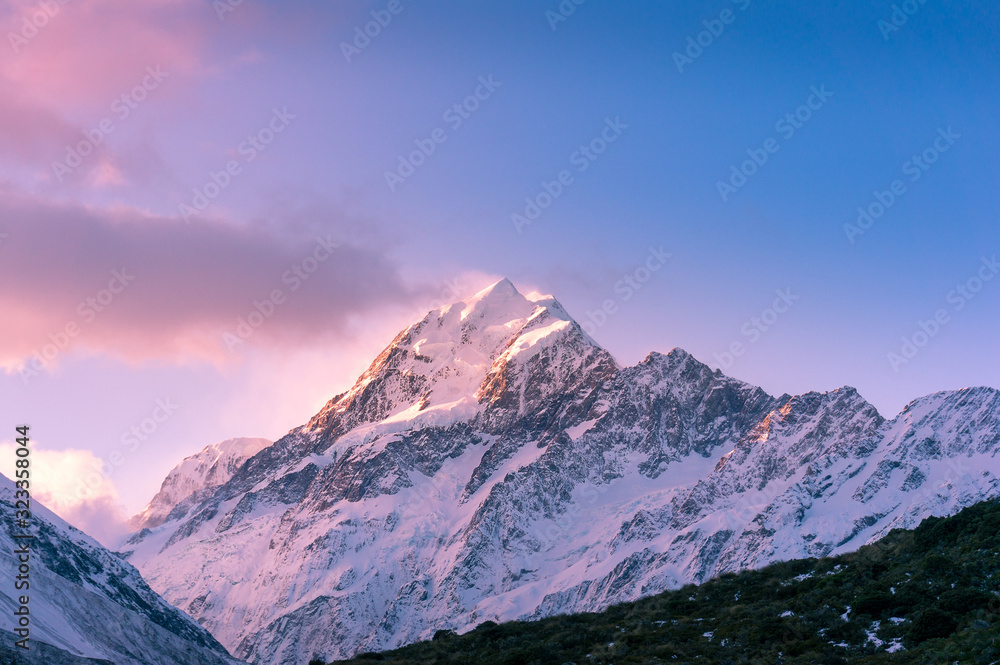 Snow covered mountain peak at sunset. Winter mountains landscape