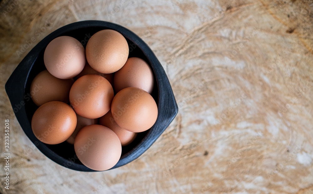 Naklejka premium Huevos sobre una mesa con tabla de madera