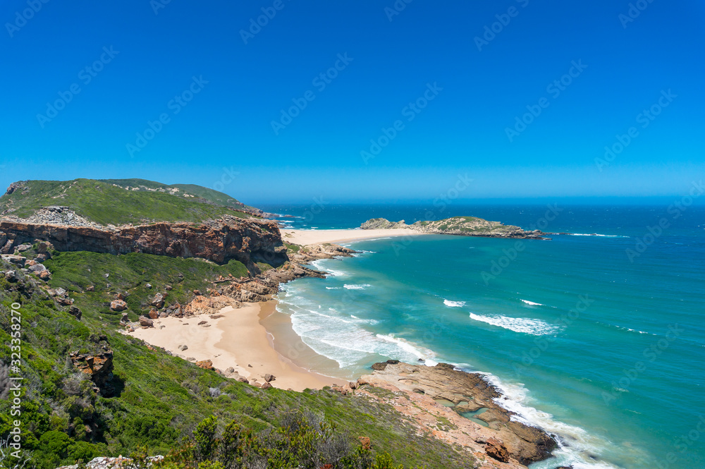 Summer seaside landscape with sandy beach and grassy hills