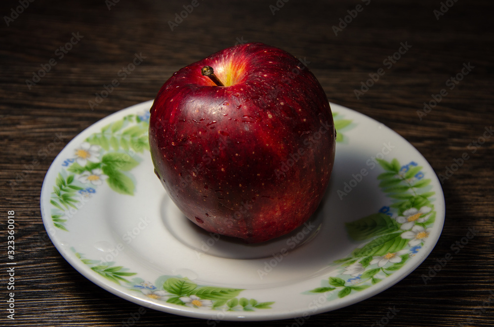 Red juicy apple on the plate Red juicy apple on the plate