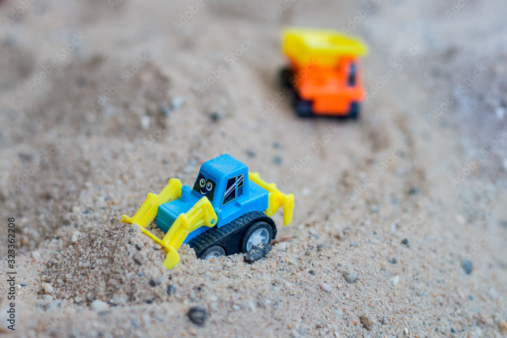 children toy truck on sand. concept of transportation and building materials children toy truck on sand. concept of transportation and building materials