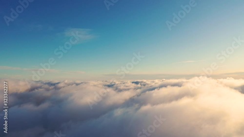 Aerial view running clouds in the sky in motion. Aerial view white clouds in blue sky during sunrise or sunset. Aerial top view cloudscape. Texture of clouds. Panoramic view. Fast playback	