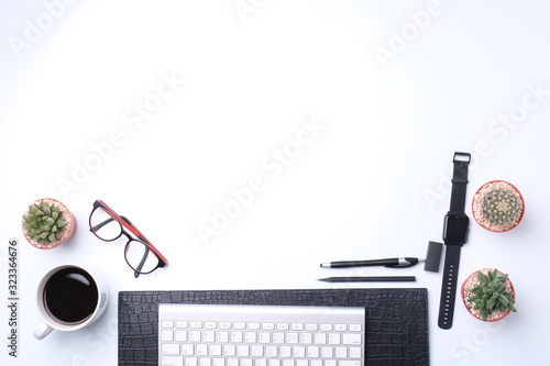 Flat lay top view office desk. Workspace with computer keyboard, office supplies, pen,eye glassesand,cactus,watches,and coffee cup on white background photo