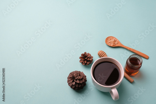 white cup coffee , pine and sugar in spoon wood on light blue background photo