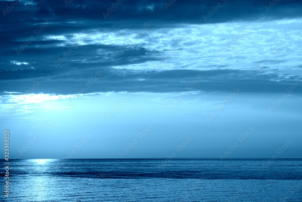 Obraz premium Sunrise over the sea near the coast of Sicily, Italy. Natural bakground blue color toned