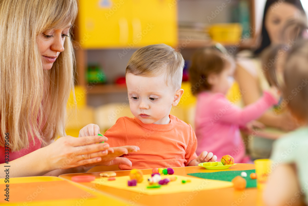 Fototapeta premium Group of children on art classes with teachers in kindergarten