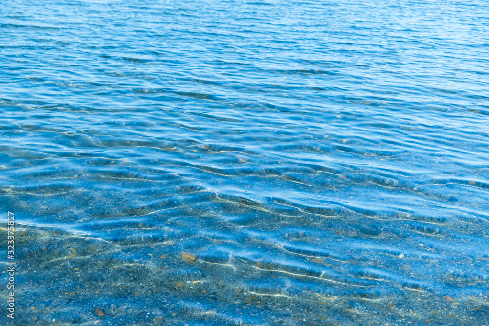Obraz premium Sea blue water surface with waves near the shore. Background texture.