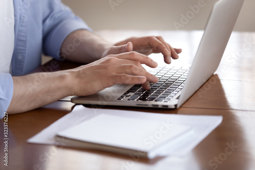 Male worker busy typing on modern laptop