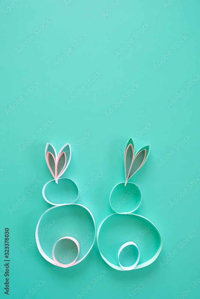 Happy easter. Easter rabbits made of paper on neo-mint background.