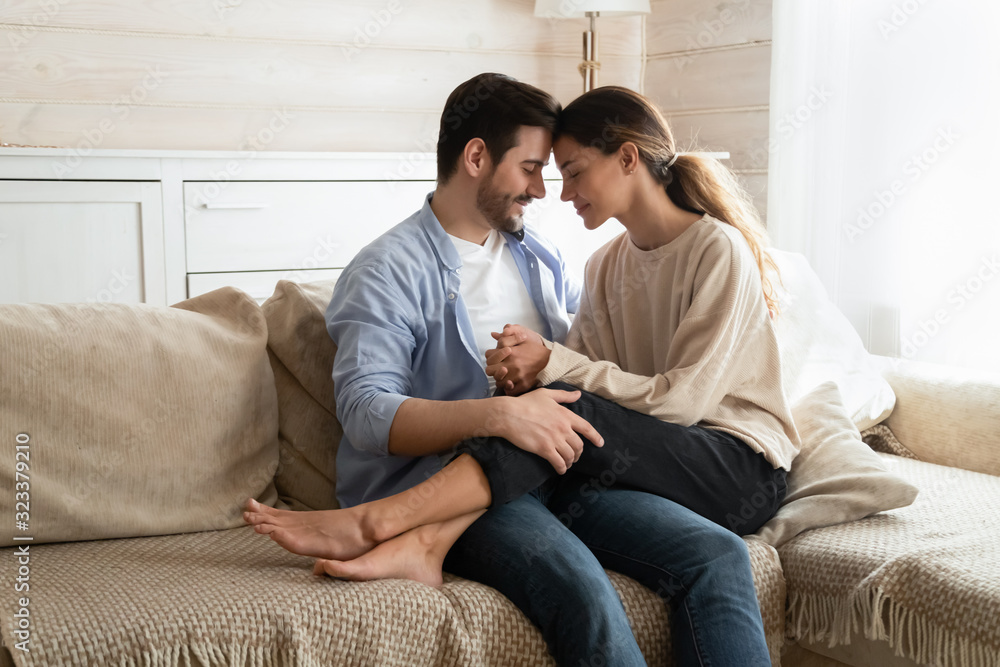 Loving young couple cuddle on couch at home Loving young couple cuddle on couch at home
