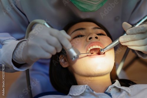 The Doctor is holding the tools for the patient.Dentist examined the patient's teeth at the clinic.Dentists perform dental floss and oral hygiene for patients at the clinic.