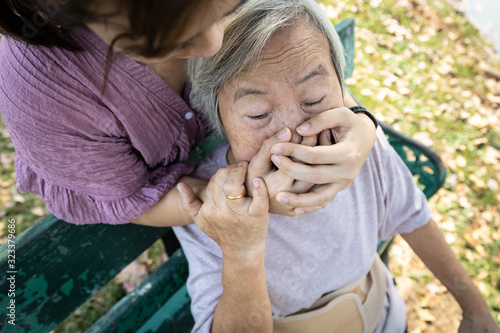 Insane asian woman would hurt senior covering mouth,nose,female caregiver was really angry with elderly,old people feeling hopeless,attacking,stop physical abuse,violence,aggression,social problems photo