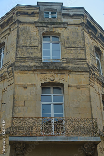 Old traditional French stone corner building with wooden windows