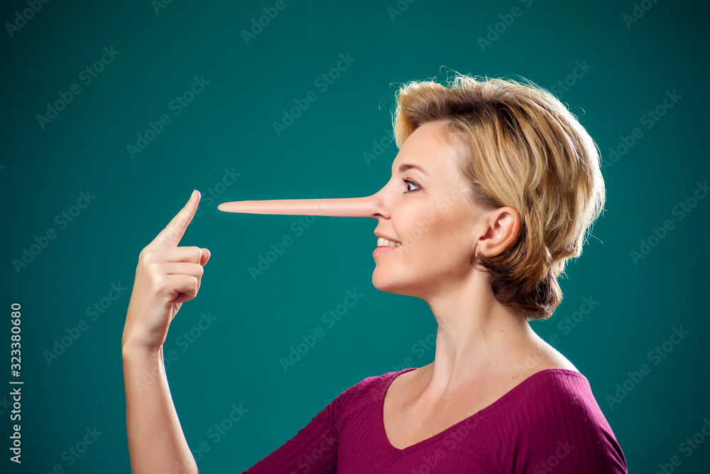 Obraz premium Woman touching her long nose because of lie . People,lifestyle and emotions concept