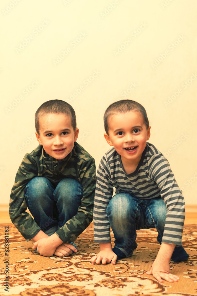 Happy children sitting at home, indoor. Two boys are playing in the ...
