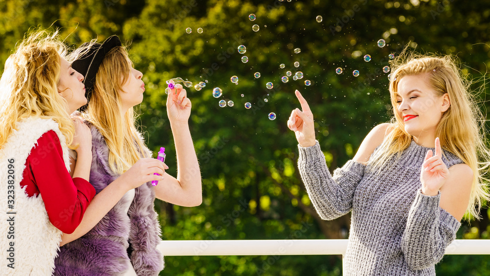 Obraz premium Women blowing soap bubbles, having fun