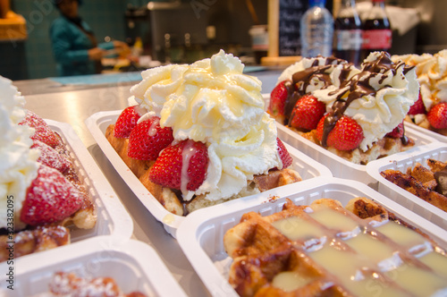 Belgium waffles with  whipped cream and strawberries for sale at sweets store