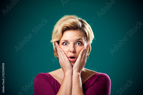 Surprized woman in front of green background . People and emotio photo